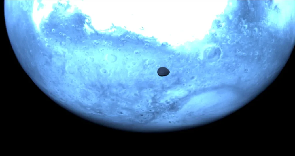 Missão Hera da ESA faz imagens inéditas de Deimos, lua de Marte 1 Deimos com Marte ao fundo, vistos a partir da sonda Hera, usando o equipamento denominado Hyperscout-H (ESA)